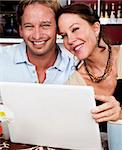 Attractive couple in cafe with laptop computer