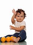 Child playing with oranges, isolated on a white background.
