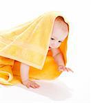 Baby boy under a yellow towel, crawling