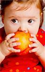 Closeup portrait of a baby eating a peach