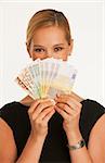 businesswoman holding up Euros in front of her face