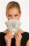 businesswoman holding up hundreds and twenty dollars in front of her face