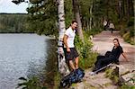 A couple hiking in the woods taking a break by the lake