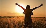 Woman silhouette waiting for summer sun on meadow