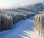 winter misty and snowfall mountain landscape with slope for skiing