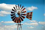 Rusty windmill with clouds in the background