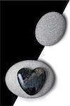 Stone heart and white pebbles on a split background