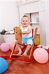 Cute smilling boy enjoy his rocking horse ride