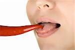 girl close up licking chili pepper isolated on white