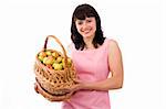 Girl in pink dress is standing and holding a basket full apples on white background. Beautiful woman holding a basket of delicious fresh fruits. Pretty girl with basket of apples. Isolated over white.