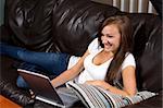 Girl at Home watching tv with while doign homework