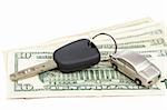Car key and dollar bills on white background with shallow depth of field