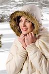 nice young woman with a white winter jacket covering her head with hood with fur