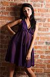 cute asian fashion model wearing purple nightgown against a brick wall