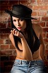 beautiful asian girl wearing a black bra and a black hat sitting with a cigar