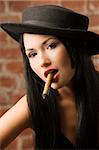 very cute asian girl with a black hat smoking a cigar