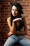 very nice asian girl with a black hat sitting and smoking a cigar