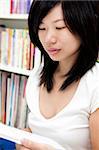 Young Asian young female student studies in the library.