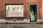 laundry in front of the window of an abandaned house with a broken door