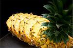 ripe vibrant pineapple sliced on a black plate