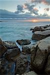 Rocky beach with sunset in the background