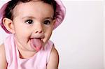 Beautiful baby with tongue hanging out. Dressed in pink