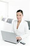 Modern businesswoman working in white office with laptop computer
