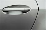 Detail shot of the door handle of a silver luxury car