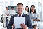 Attractive smiling manager writing notes in a call center