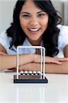 Businesswoman playing with kinetic balls in office