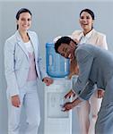 Business team drinking from a water cooler in office