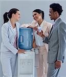 Business people speaking next to a water cooler in office