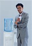 Afro-American businessman with a water cooler in office