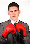 Serious businessman with boxing gloves looking at the camera