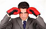 Stressed businessman with boxing gloves looking at the camera
