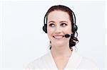 Beautiful businesswoman with a headset on looking upwards against white background