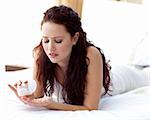 Worried woman lying in bed taking pills