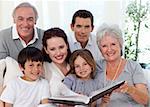 Smiling family looking at a photograph album at home