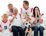 Family watching a football match in television at home