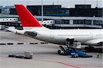 Aircraft standing at gate and being loaded with luggage