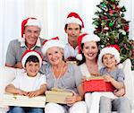 Happy family holding Christmas presents at home