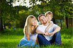 Smiling family has rest on a summer lawn