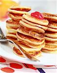 Sweet pancakes with compote and pancake maker background