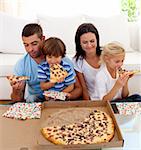 Happy family eating pizza in living-room all together