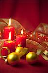 Christmas decoration with candles and ribbons / red and golden