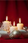 Christmas decoration with candles and ribbons / red and silver