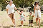 Family running with two young children at the park