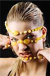 portrait of blond girl pulling off a yellow stone necklace from her face