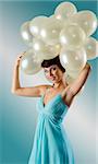 vintage shot of pretty brunette in elegant green dress with air ballons on her head