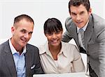 Smiling business team working together with a computer in an office